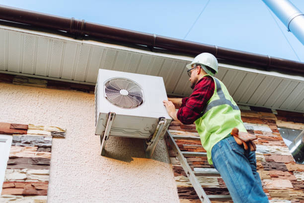 technician in uniform repairing heat pump technician in uniform repairing heat pump